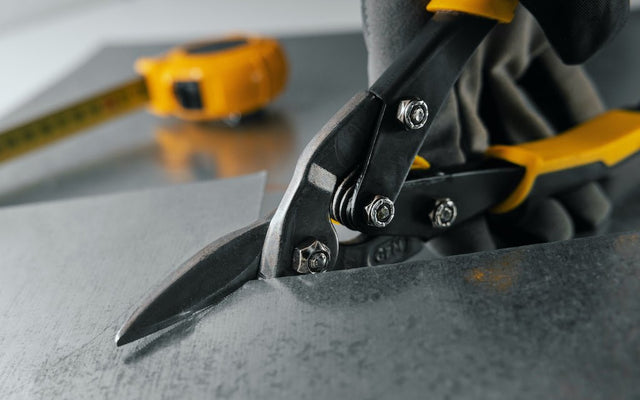 Tin snips cutting a ceiling tile — custom fits guide